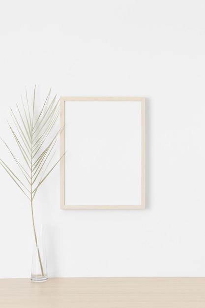 Houten frame mockup aan de muur met een palmblad