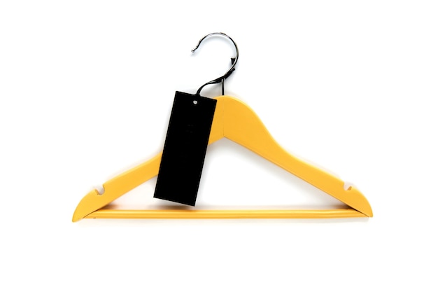 Houten gele kleerhanger met zwart papieren label geïsoleerd op een witte achtergrond. Kledinglabel, label b