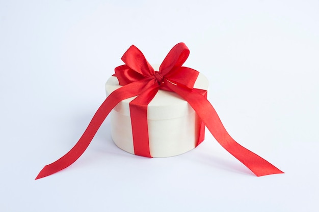 Houten geschenkdoos met gebonden rode strik op de witte achtergrond