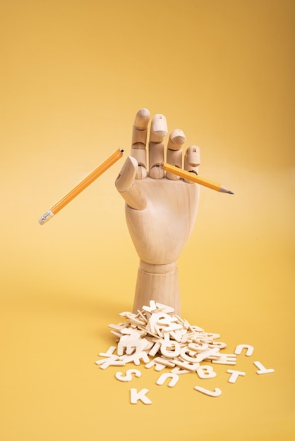 Houten hand met een gebroken potlood en houten letters Foto van hoge kwaliteit