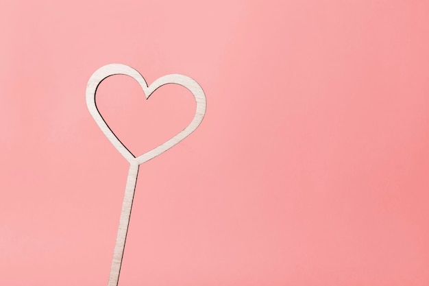Foto houten hart op een roze achtergrond. wenskaart concept. plaats onder copyspace
