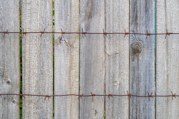 Houten hek met roestig prikkeldraad