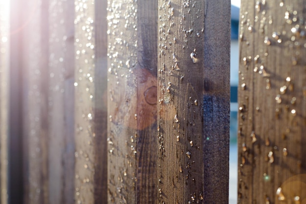 Houten hek met waterdruppels na regen