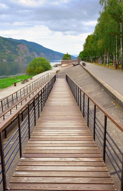 Houten helling aan de oever van de grote siberische rivier met rotsachtige kusten divnogorsk siberië rusland