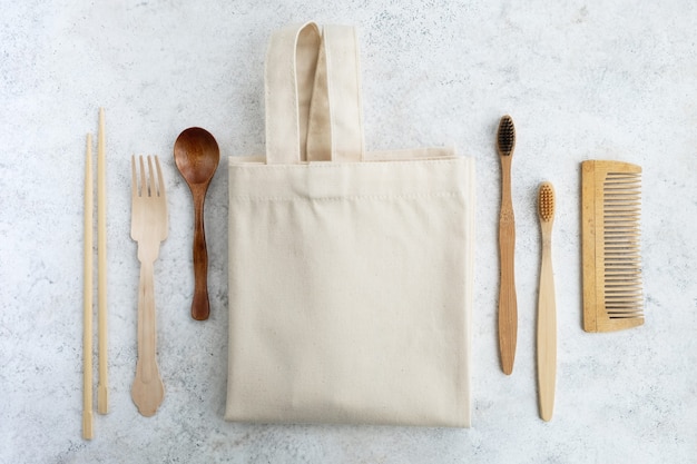 Foto houten herbruikbare badkameraccessoires en een tas op een lichte marmeren achtergrond