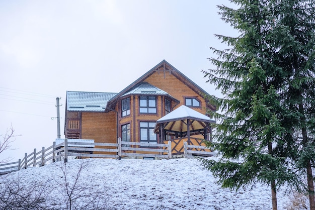 Houten huis in een prachtig wintergroen naaldbos op de hellingen van de bergen Openluchtrecreatie in het winterseizoen