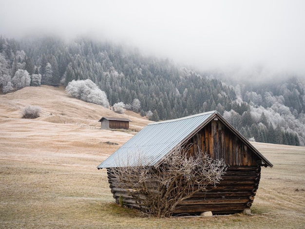 Houten huis op sneeuw bedekt land tegen de lucht