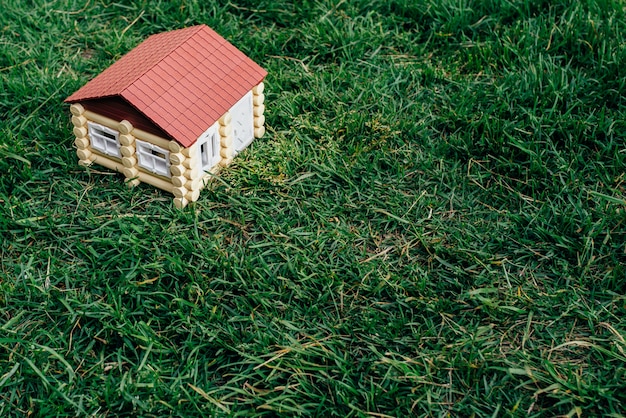 Houten huis uit een logboek tegen een gras