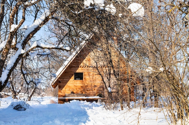 Houten huisje in besneeuwde tuin in de winter