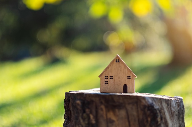 Houten huismodel op boomstronk in de buitenlucht