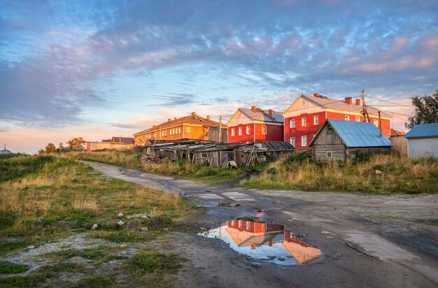 Houten huizen van het dorp op de Solovetsky-eilanden in de stralen van de ondergaande zon