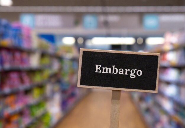 Houten informatielabel met tekst EMBARGO tegen onscherp bericht in winkelschappen