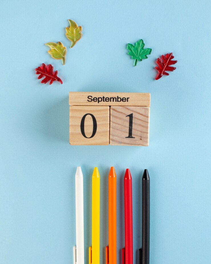 houten kalender van 1 september, gekleurde pennen op een blauwe achtergrond. begin van het schooljaar
