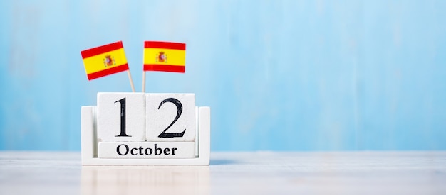 Houten kalender van 12 oktober met miniatuur vlaggen van Spanje.