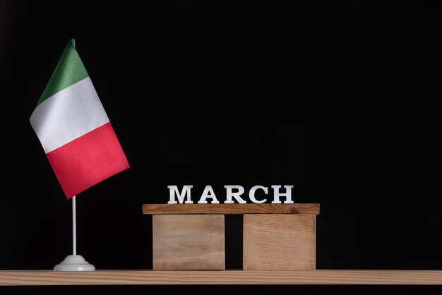 Houten kalender van maart met Italiaanse vlag op zwarte achtergrond. Datums in Italië in maart.