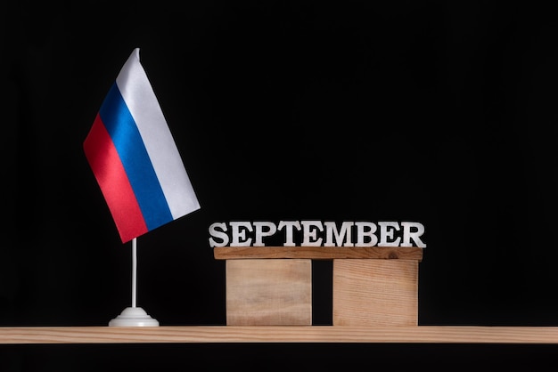 Houten kalender van september met Russische vlag op zwarte achtergrond Datums in Rusland in september