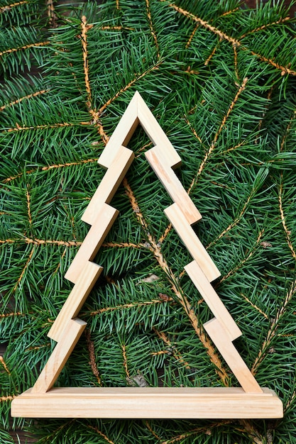 Foto houten kerstboom op een achtergrond van groene sparren takken