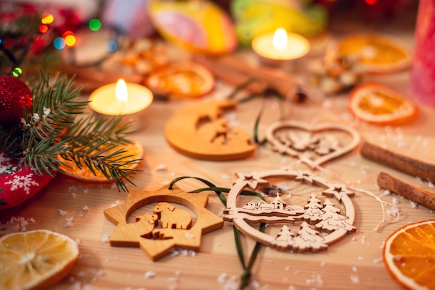 Houten kerstboomspeelgoed op een bureau, omringd door kaarsen en verschillende decoraties