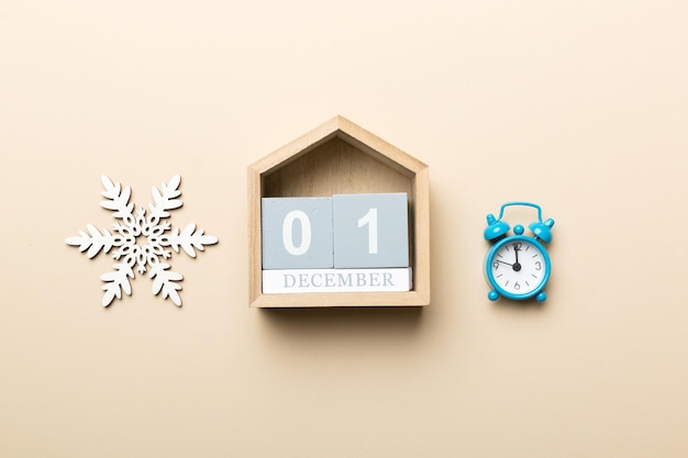 Houten kerstkalender met nieuwjaarsversieringen tegen gekleurde achtergrond Kerstkalender 1 december