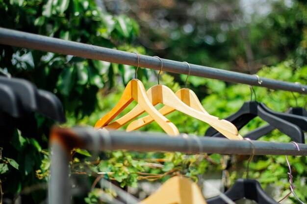 Foto houten kledinghanger met een natuurlijke bladachtige achtergrond in de tuin