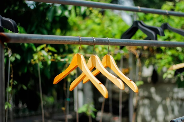 Foto houten kledinghanger met een natuurlijke bladachtige achtergrond in de tuin