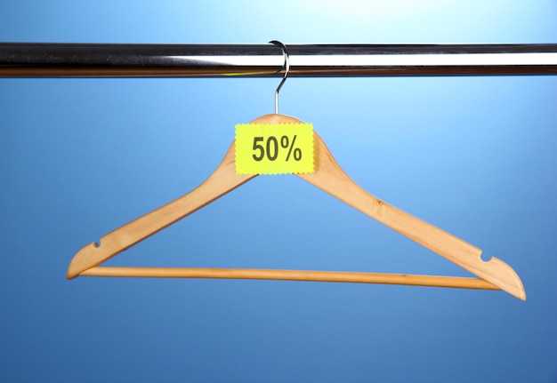 Foto houten kleerhanger als verkoopsymbool op blauwe achtergrond