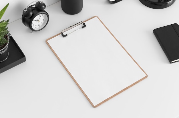 Houten klembordmodel met werkruimteaccessoires op een witte tafel