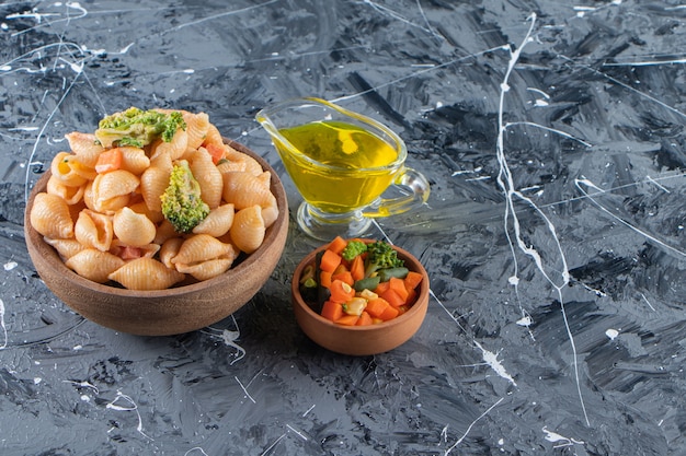 Houten kom lekkere zeeschelppasta met verse salade op marmeren oppervlak.