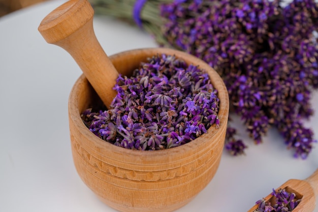 Houten kom met gedroogde lavendel op veld achtergrond Bloem kruidenthee drinken Aromatherapie geneeskunde ingrediënt Kalmerende drank