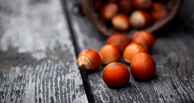 Houten kom met hazelnoten op een zwarte houten tafel