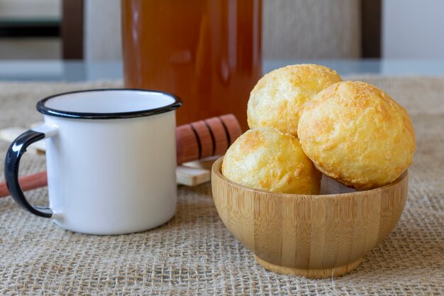 Houten kom met kaasbrood en witte koffiemok