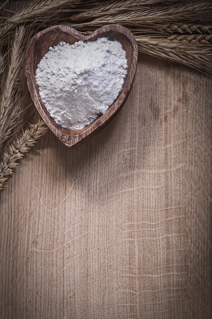 Houten kom met meel bos gouden rogge tarwe oren eten en drinken concept