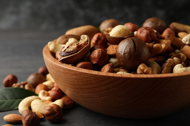 Houten kom met verschillende smakelijke noten op grijze houten