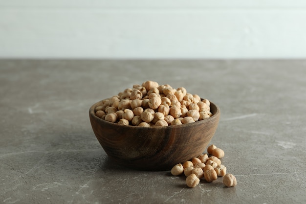 Houten kom met verse kikkererwten op grijze tafel