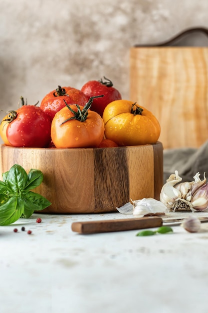 Houten kom tomaten knoflook basilicum peper en mes Keuken stilleven in rustieke stijl Ruimte kopiëren