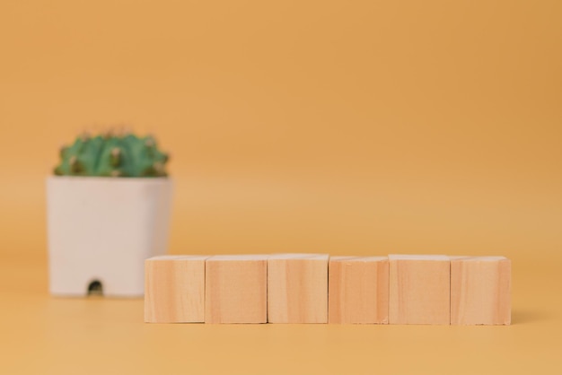 Houten kubusblok leeg en boom op gele achtergrond