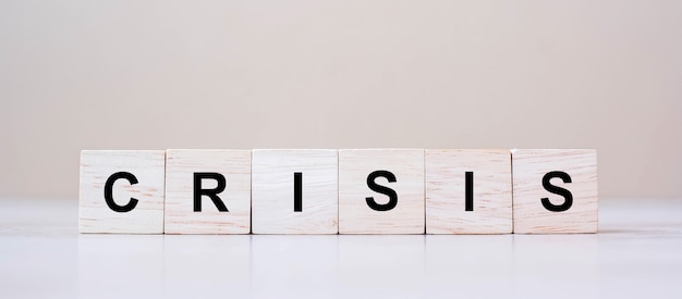Houten kubusblokken met CRISIS-tekst op lijstachtergrond