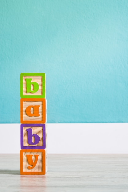 Houten kubussen met letters met babywoord op witte houten tafel