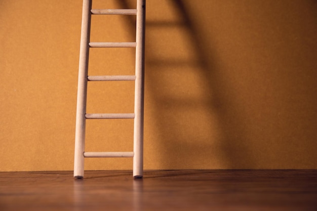 Houten ladder op bruine muur