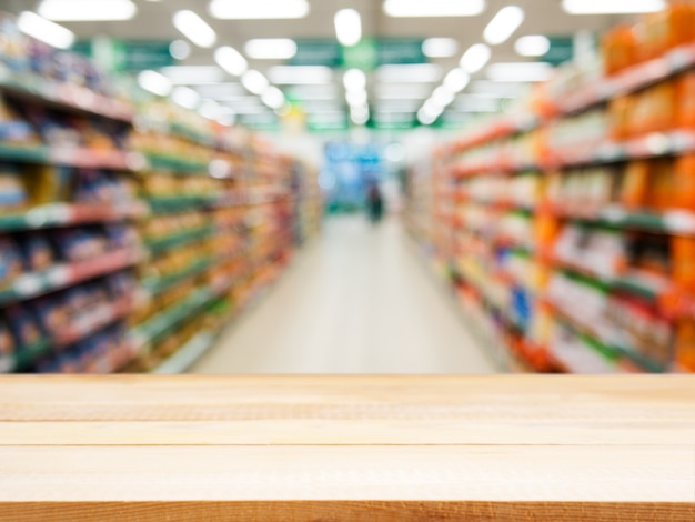 Houten lege tafel voor wazig supermarkt