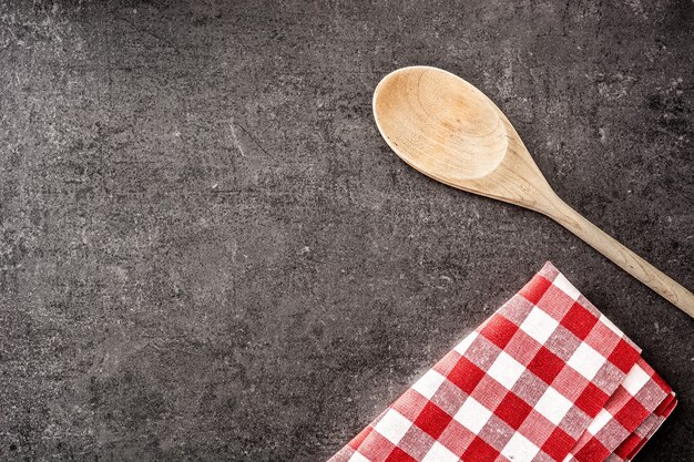 Houten lepel en geruit tafelkleed op zwart