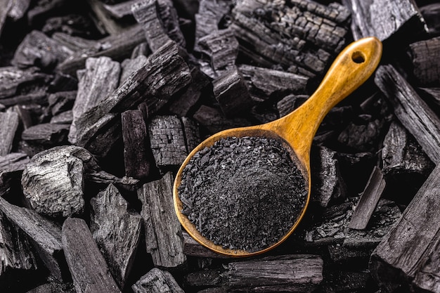 Houten lepel met kolenstof op stukjes steenkool