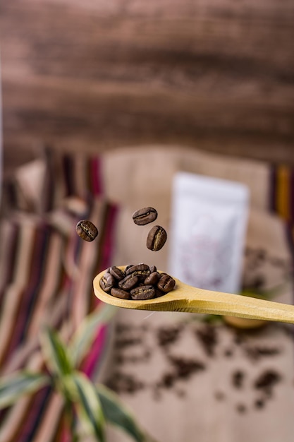 Foto houten lepel met vallende koffiebonen