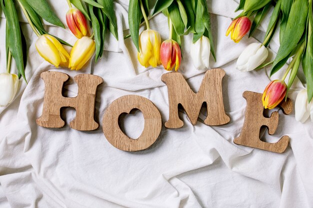 Foto houten letters thuis op een tafel met tulpenbloemen