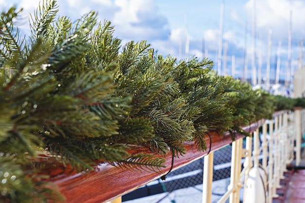 Houten leuning versierd met dennenkrans en kerstverlichting. buitendecor tijdens de kersttijd