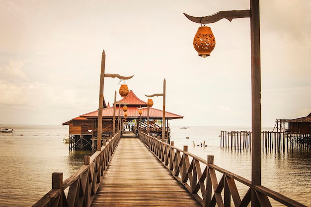 Houten loopbrug die zich uitstrekt in de zee, Mabul-eiland, Sabah, Maleisië