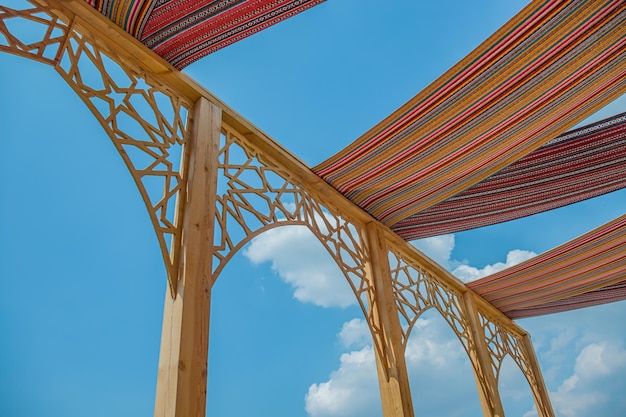 Houten luifel van de zon Gewoven doek op de achtergrond van de hemel