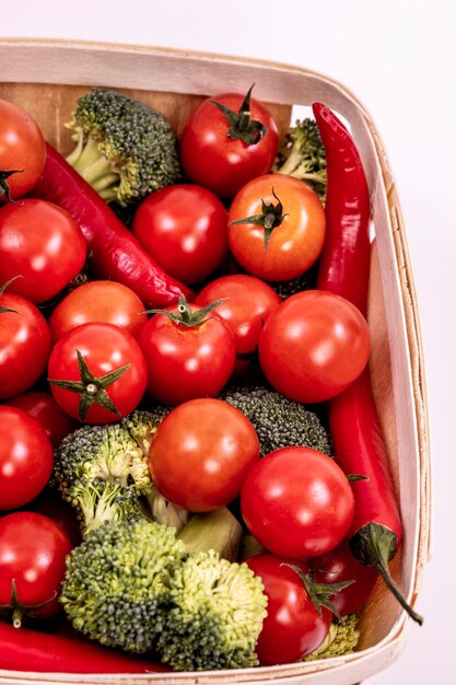 Houten mand gevuld met kerstomaatjes groene broccoli takjes