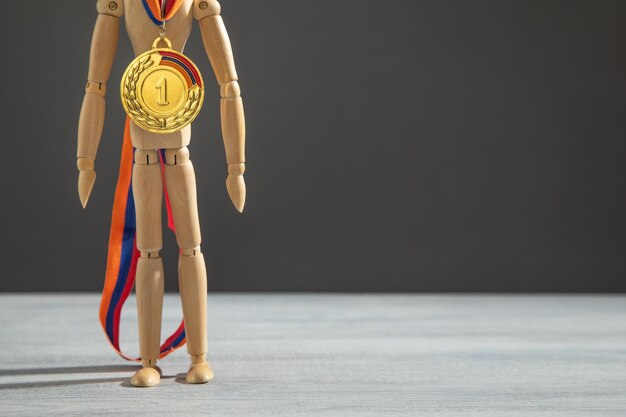 Houten menselijke figuur met een winnende medaille