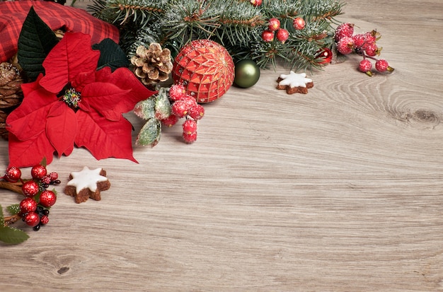 Houten met poinsettia en gedecoreerde kerstboomtakjes